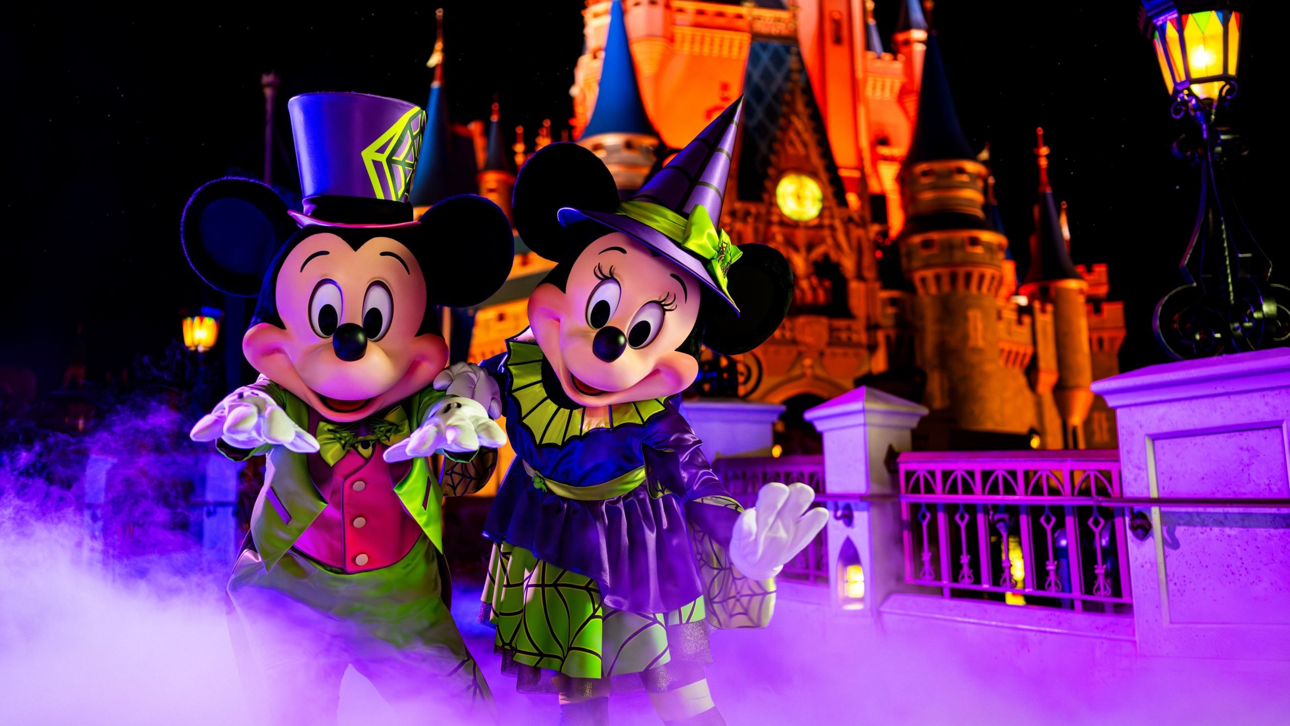 Família aproveitando o Halloween nos parques de Orlando com castelo iluminado ao fundo